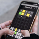 A close up photo of a woman playing Wordle on her phone.
